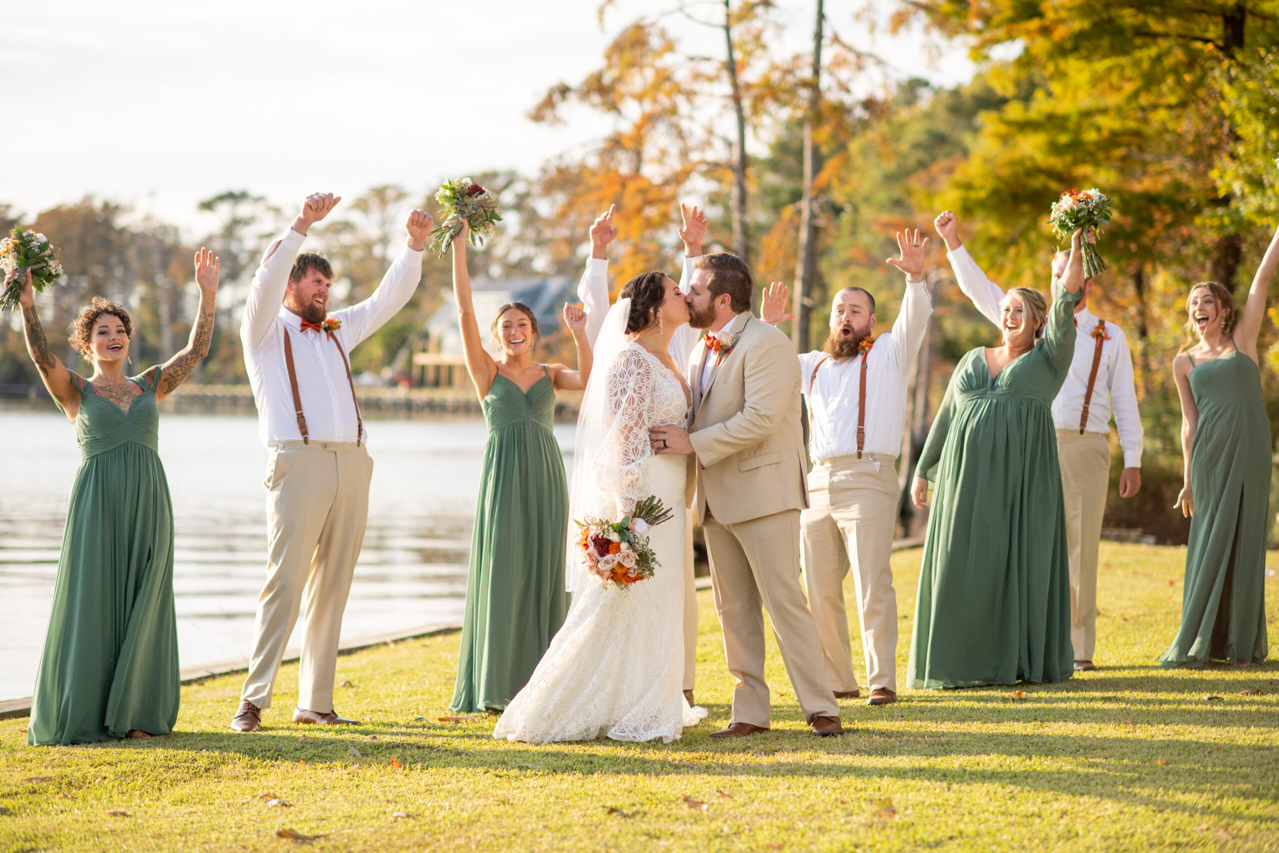 Wedding party celebrates Bride and Groom kissing after ceremony